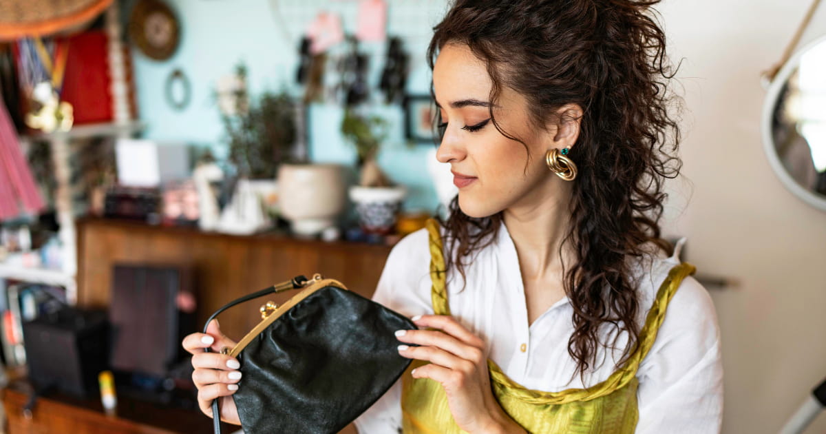 femme qui tient un sac d'occasion dans un magasin de seconde main