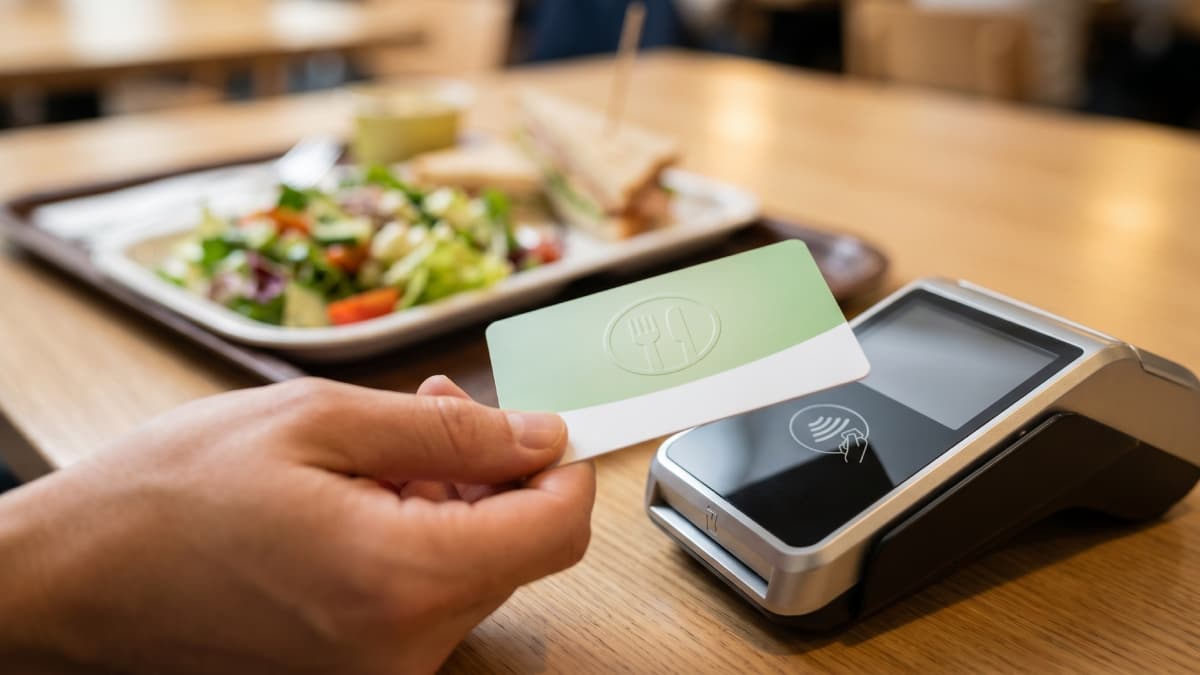 Paiement avec une carte chèques-repas sur un terminal.