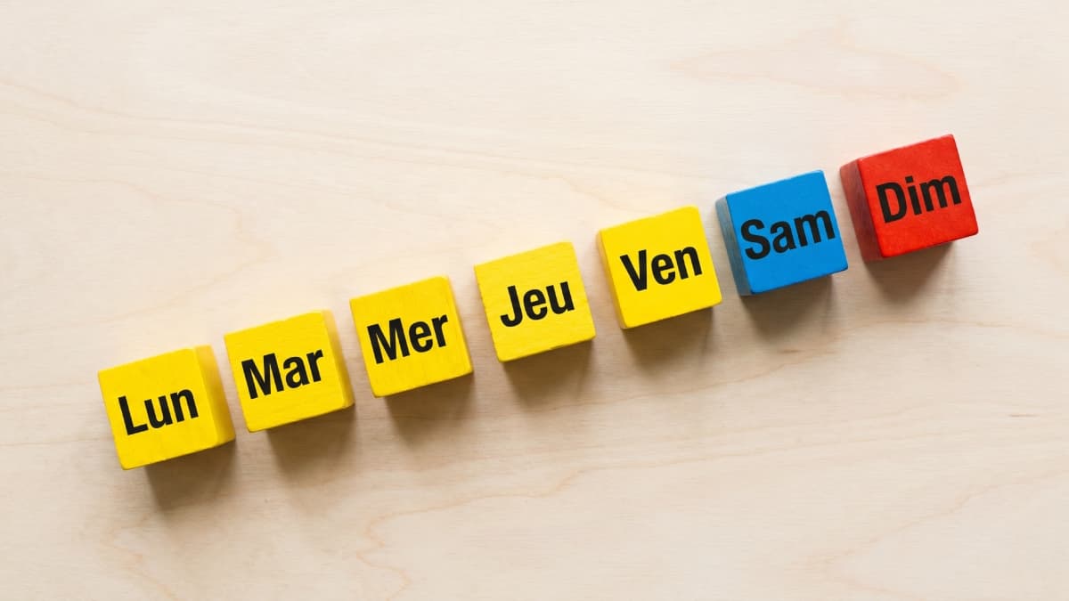 Jours de la semaine sur des petits dés de couleurs différentes.