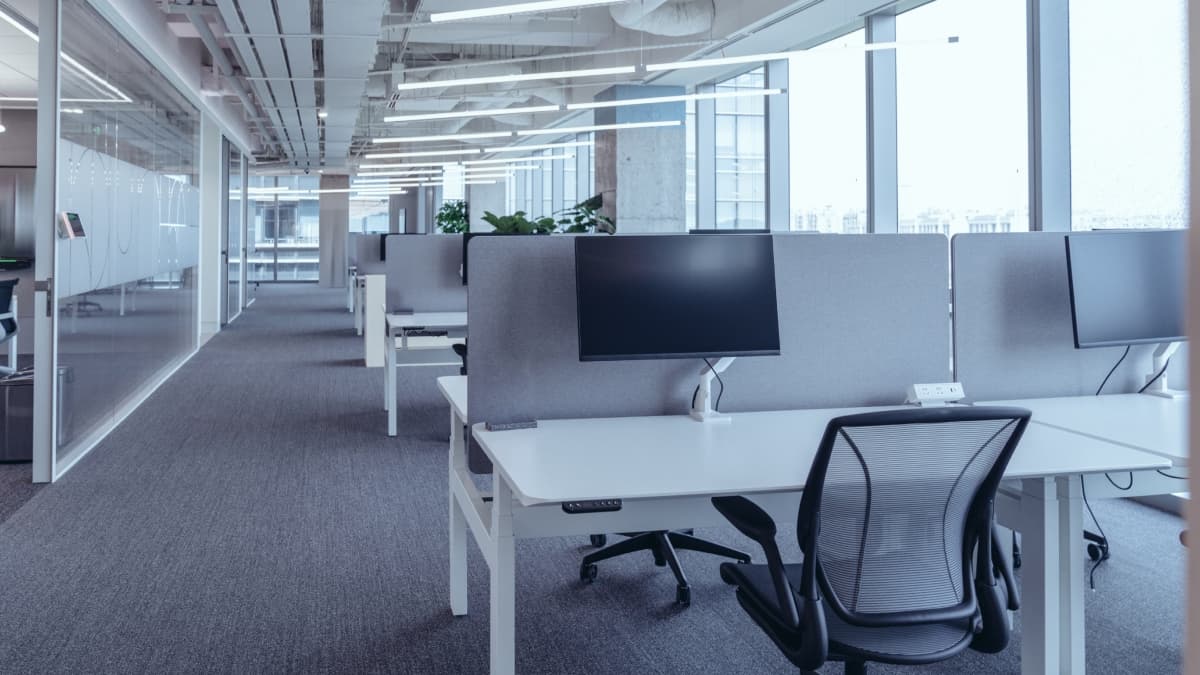 Open space d'une entreprise avec des bureaux et ordinateurs.