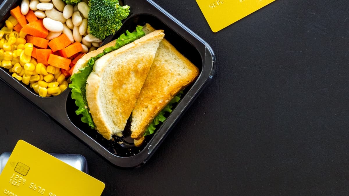 Paiement d'un repas avec une carte sur un terminal de paiement.