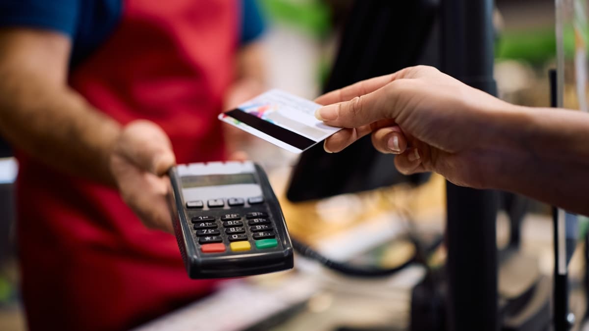 Paiement sans contact sur un terminal de paiement avec une carte dans un supermarché.